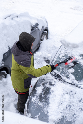 Obraz na płótnie Person Clearing Snow from Car in Winter Landscape w salonie