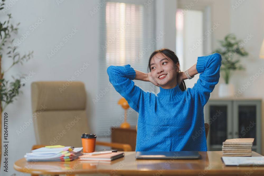 Young woman in a bright office setting, taking a break with a relaxed posture. Desk is organized with documents, a laptop, and a coffee cup, suggesting a productive work environment Young woman in a bright office setting, taking a break with a relaxed posture. Desk is organized with documents, a laptop, and a coffee cup, suggesting a productive work environment