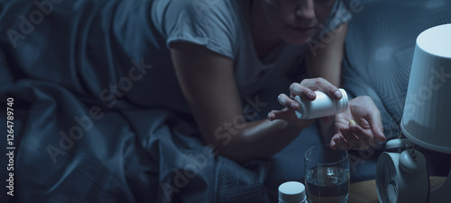Billede på lærred Woman taking prescription drugs at night