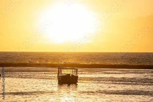 Fototapeta Naklejka Na Ścianę i Meble -  Serene sunset with silhouetted boat on ocean.