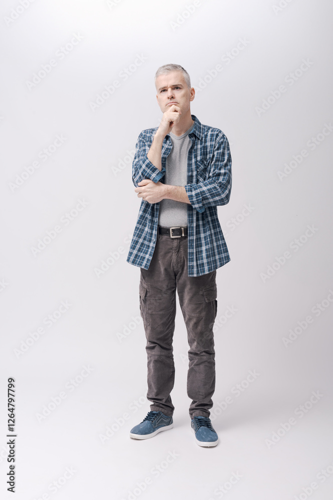 Man standing and thinking with hand on chin Man standing and thinking with hand on chin