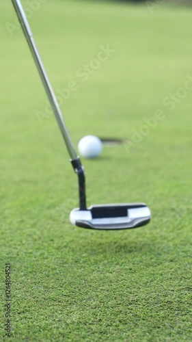 A golf ball is on a green grass field ready for the putt.