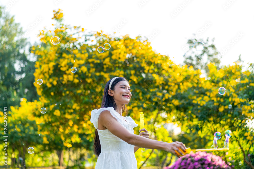 Fototapeta premium Asian Woman Blowing Bubbles in a Park