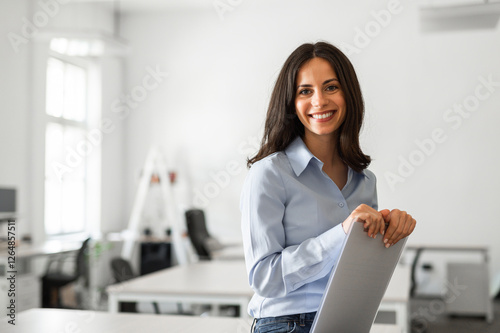 Portrait of young woman in her office smiling
