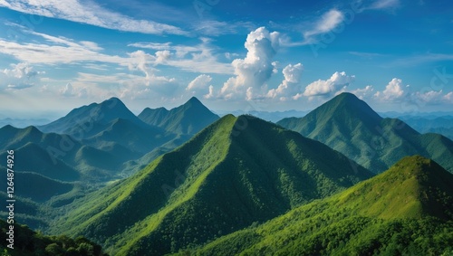 Lush green mountain range under a clear blue sky with fluffy clouds natural landscape and Copy Space