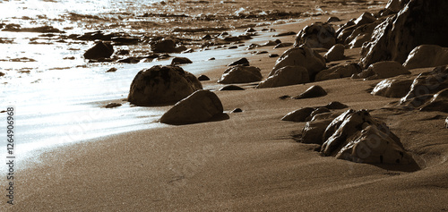 Serene coastal landscape at sunrise with smooth rocks and gentle waves