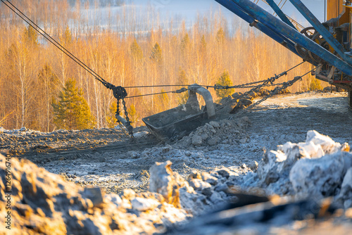Tablou pe pânză Open-pit coal mining in winter landscape with heavy machinery, Land reclamation