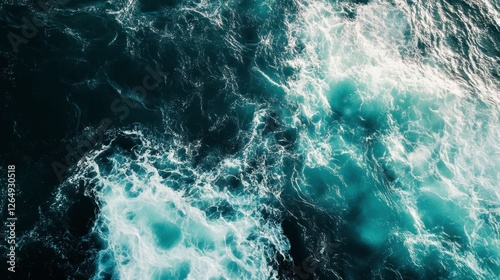 A high-resolution drone shot of swirling ocean currents, with foamy white waves painting natural abstract pat
