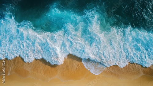 A mesmerizing top-down shot of turquoise waves gently rolling onto a golden sandy beach, forming a rhythmic contrast between land and sea.