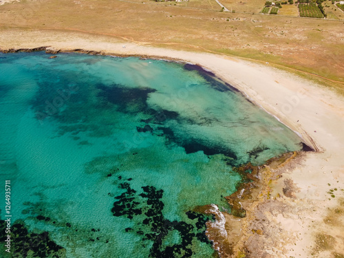 Aerial drone view of Macari (Makari), Sicily. Crystal clear turquoise waters, rugged cliffs, golden sandy beaches. A serene natural landscape with Mediterranean charm near San Vito lo Capo. photo