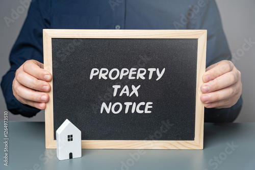Property tax notice concept. Official document issued by local government authorities to inform property owners of the amount of property tax they owe for a specific period. board with words in hands