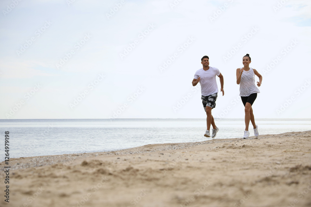 Couple running together on beach, space for text. Body training Couple running together on beach, space for text. Body training