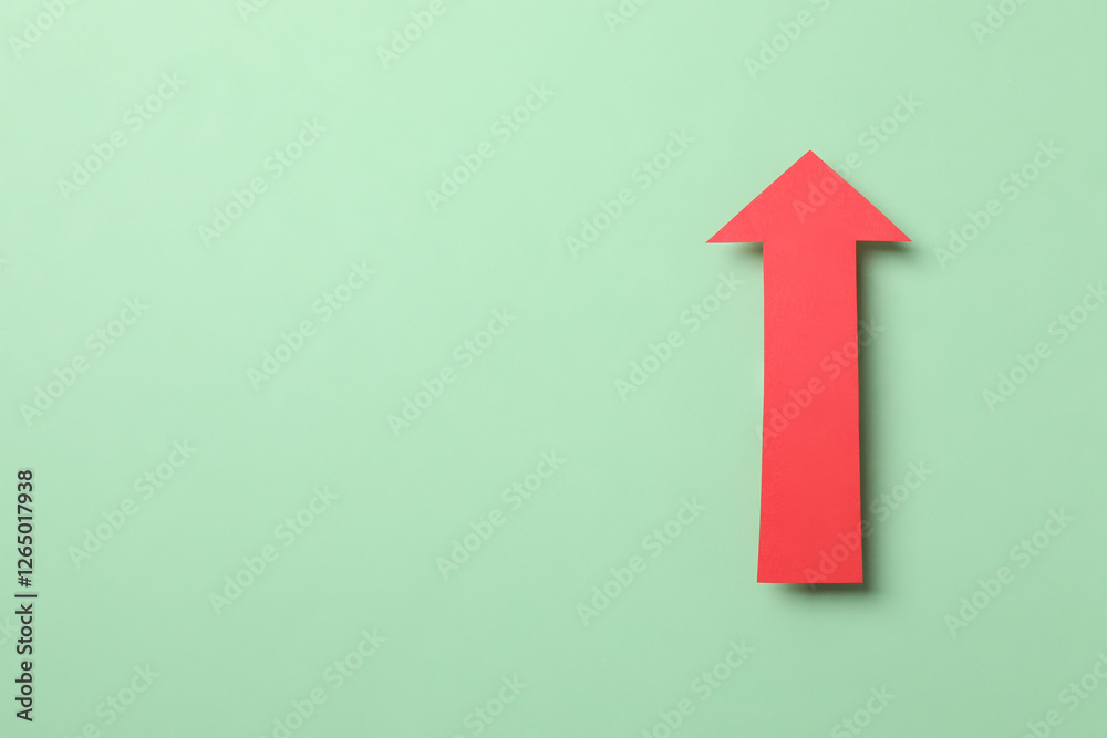 Paper arrow on color background, top view