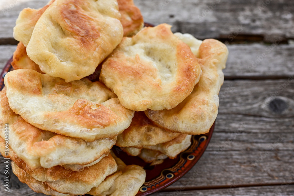 Traditional Bulgarian home made deep fried patties covered with sugar оn rustic backgroud.Mekitsa or Mekica, on wooden rustic background. Made of kneaded dough that is deep fried Traditional Bulgarian home made deep fried patties covered with sugar оn rustic backgroud.Mekitsa or Mekica, on wooden rustic background. Made of kneaded dough that is deep fried