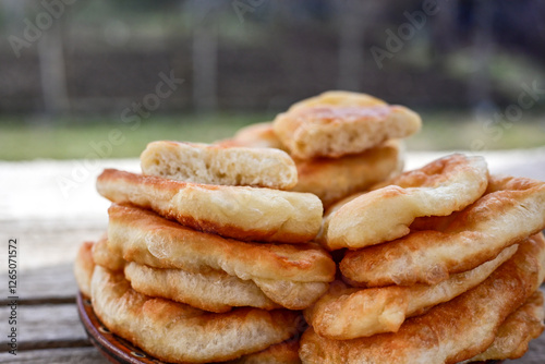 Traditional Bulgarian home made deep fried  patties  covered with sugar  оn rustic backgroud.Mekitsa or Mekica,  on wooden  rustic  background. Made of kneaded dough that is deep fried  photo