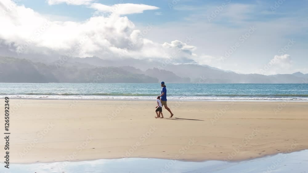 A father and son enjoy a stroll on Punta Uvita beach, surrounded by the stunning scenery of Marino Ballena National Park, making lasting memories A father and son enjoy a stroll on Punta Uvita beach, surrounded by the stunning scenery of Marino Ballena National Park, making lasting memories