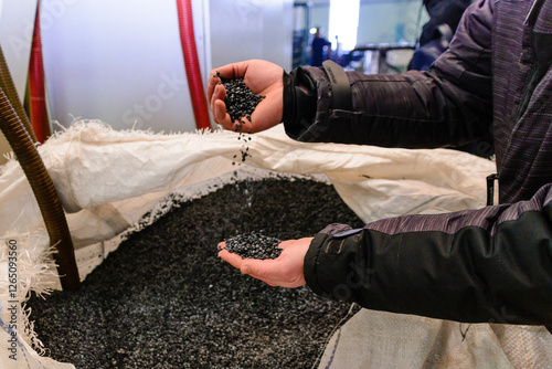 hands hold or touching biodegradable plastic pellets, plastic polymer granules