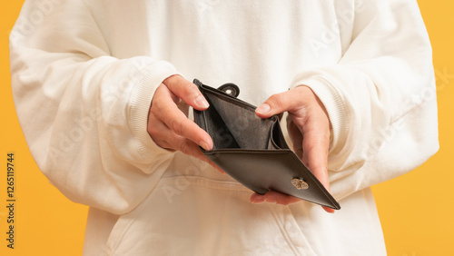 Person holding a black wallet open showing no contents