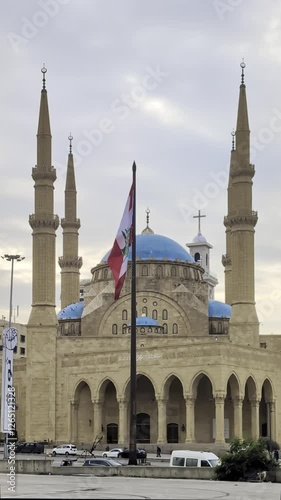 Beirut, Lebanon 01 26 2025: Al Amin mosque with blue domes and Christian church with a cross in downtown Beirut. Lebanese flag prominent. Diversity, religious coexistence, national identity. Vertical