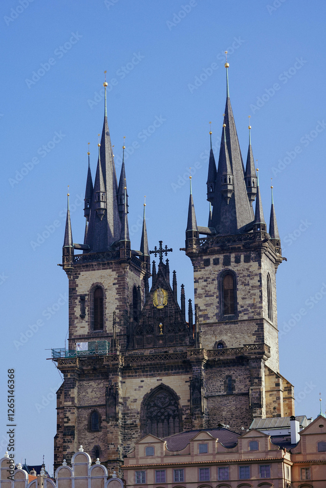 The scene features a tall church tower with multiple spires under a bright blue sky The scene features a tall church tower with multiple spires under a bright blue sky