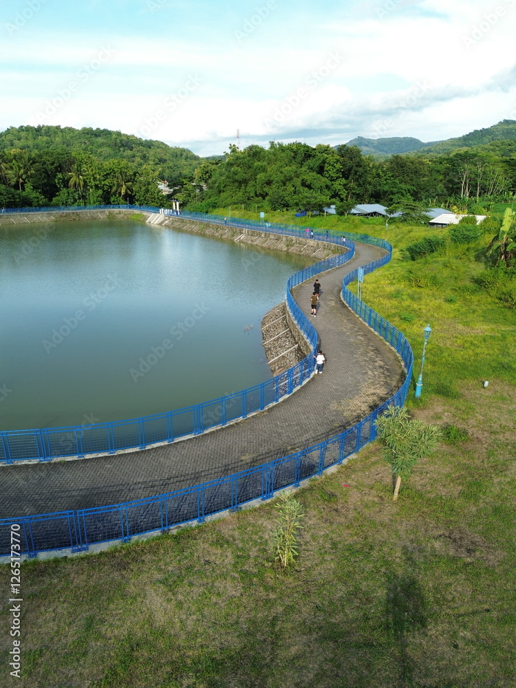 Fototapeta premium Aerial View of Green Fields Surrounding a Trapezoidal Pond in Rural Landscape