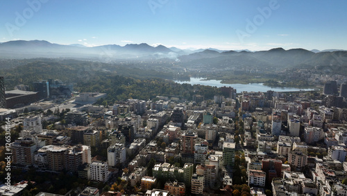 Wallpaper Mural Aerial view of Tirana’s city center on a sunny day, showcasing Skanderbeg Square, modern high-rises, and historic landmarks, with Dajti Mountain in the background. Photo taken 16,11,2024, Tirana, Alba Torontodigital.ca