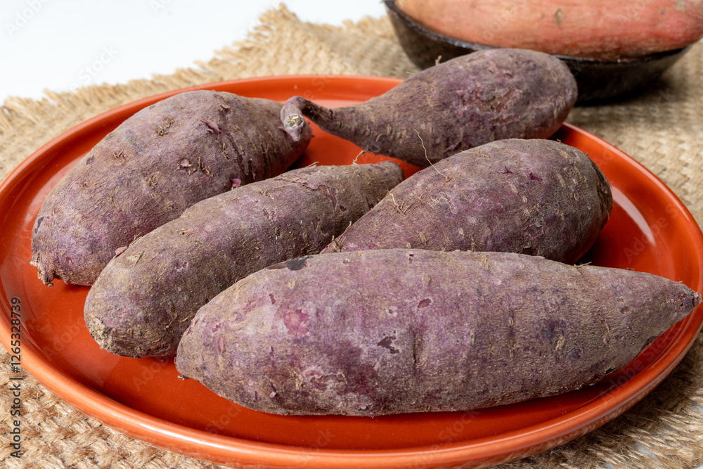 Colorful sweet-tasting tuberous roots vegetables purple and orange organic sweet potatos close up Colorful sweet-tasting tuberous roots vegetables purple and orange organic sweet potatos close up