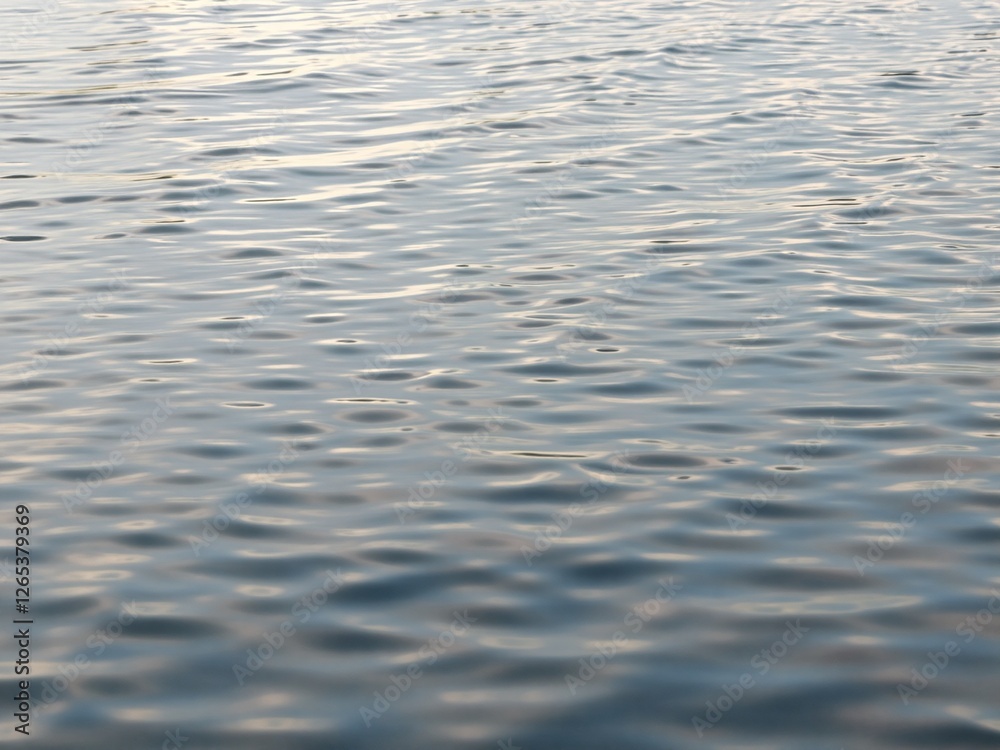 Soft ripples and abstract reflections on the surface of still water, creating a mesmerizing texture Soft ripples and abstract reflections on the surface of still water, creating a mesmerizing texture