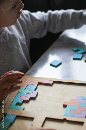 older sister and brother playing logical wooden puzzles