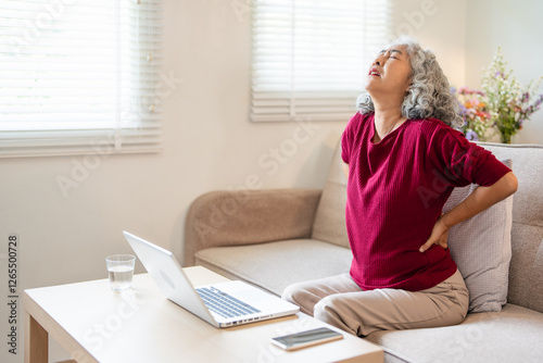 Worried upset middle aged mature woman feel hurt sudden back ache touch sore spine at home alone, tired mature senior grandmother having lower lumbago backache injury spinal pain, backpain concept photo