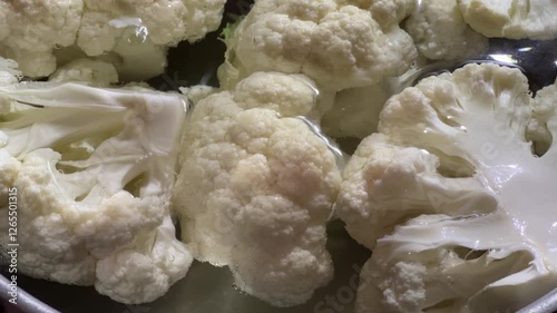 Cauliflower pieces in hot water during their blanching in pot