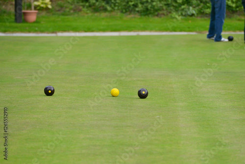 Crown green bowling on an outdoor green in rural Shropshire. The bowls are thrown towards the yellow jack and the nearest is awarded a point. A competitive  game played in teams or alone. 