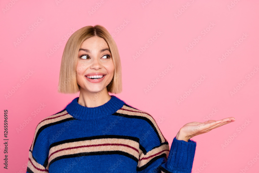 Smiling blonde woman in striped sweater gesturing on pink background Smiling blonde woman in striped sweater gesturing on pink background