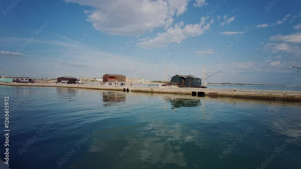 A picturesque view of the Cesenatico canal harbor, featuring traditional fishing trawlers and historic wooden docks. A picturesque view of the Cesenatico canal harbor, featuring traditional fishing trawlers and historic wooden docks.