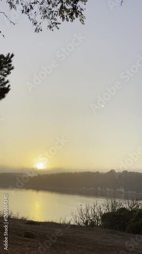 Arriving at scenic overlook at sunrise over calm lake or sea. Camp morning