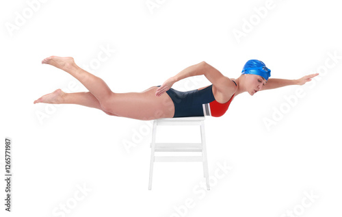 Professional sportswoman in swimsuit and cap practicing dryland swimming on white background