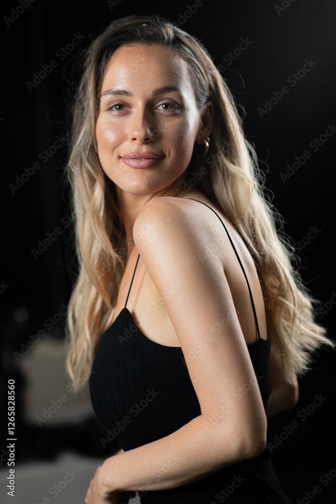 Naklejka premium Radiant Elegance: A Stunning Blonde in a Black Dress Exuding Confidence and Beauty.