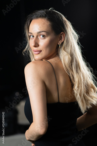 Radiant Elegance: A Stunning Blonde in a Black Dress Exuding Confidence and Beauty.