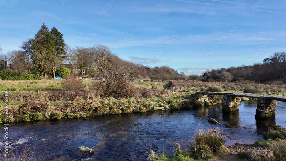 Postbridge Dartmoor Devon England UK. 10.02. 2025. Video. Overview of the East Dart River flowing towards a clapper bridge on Dartmoor Devon UK. Postbridge Dartmoor Devon England UK. 10.02. 2025. Video. Overview of the East Dart River flowing towards a clapper bridge on Dartmoor Devon UK.