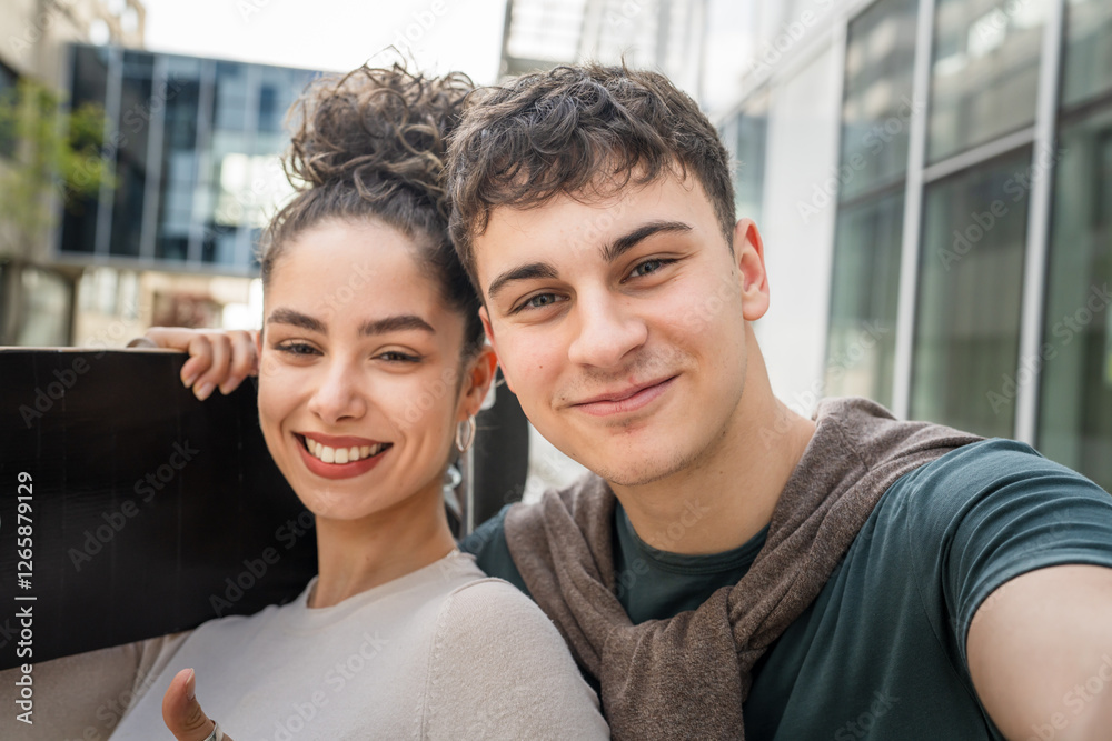 Young man and woman teenager couple take selfies by modern building