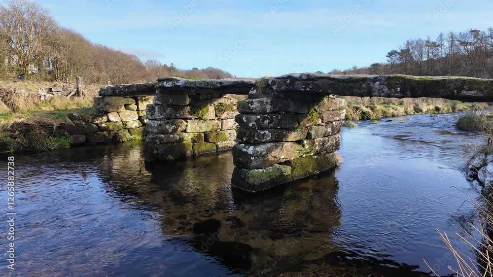 Postbridge Dartmoor Devon England UK. 10.02. 2025. Video. Overview of the East Dart River flowing towards a clapper bridge on Dartmoor Devon UK. Postbridge Dartmoor Devon England UK. 10.02. 2025. Video. Overview of the East Dart River flowing towards a clapper bridge on Dartmoor Devon UK.