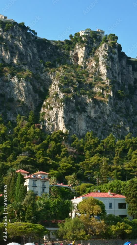 Rugged cliffs and hills of the Maritime Alps, that rise behind Beaulieu-sur-Mer. Vertical Rugged cliffs and hills of the Maritime Alps, that rise behind Beaulieu-sur-Mer. Vertical