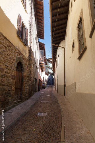 Obraz na płótnie Street view of historical village Gromo, Bergamo, Lombardy, Italy. Narrow cobbled streets. Sun lights and shadows. w salonie