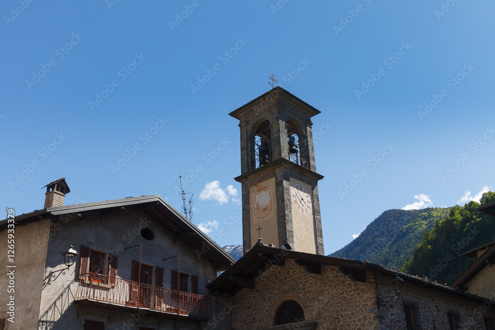GROMO, ITALY - MAY 22, 2024: Street view of historical village with narrow cobbled streets, shot in bright summer light. Clock tower.