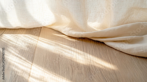 Sunlight filtering through sheer linen curtain onto wooden floor
