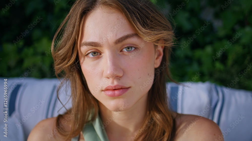 Attractive model looking camera sitting terrace surrounded greenery closeup. Attractive model looking camera sitting terrace surrounded greenery closeup.