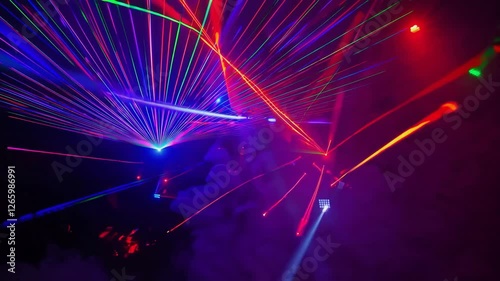 Vivid Laser Light Show Glowing Through Colorful Smoke Creating Mesmerizing Abstract Patterns in Night Sky