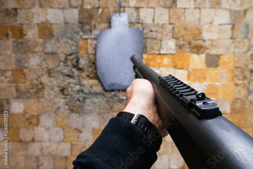 Fotografie Tactical shotgun shooting at a target in a shooting range, first person view photo
