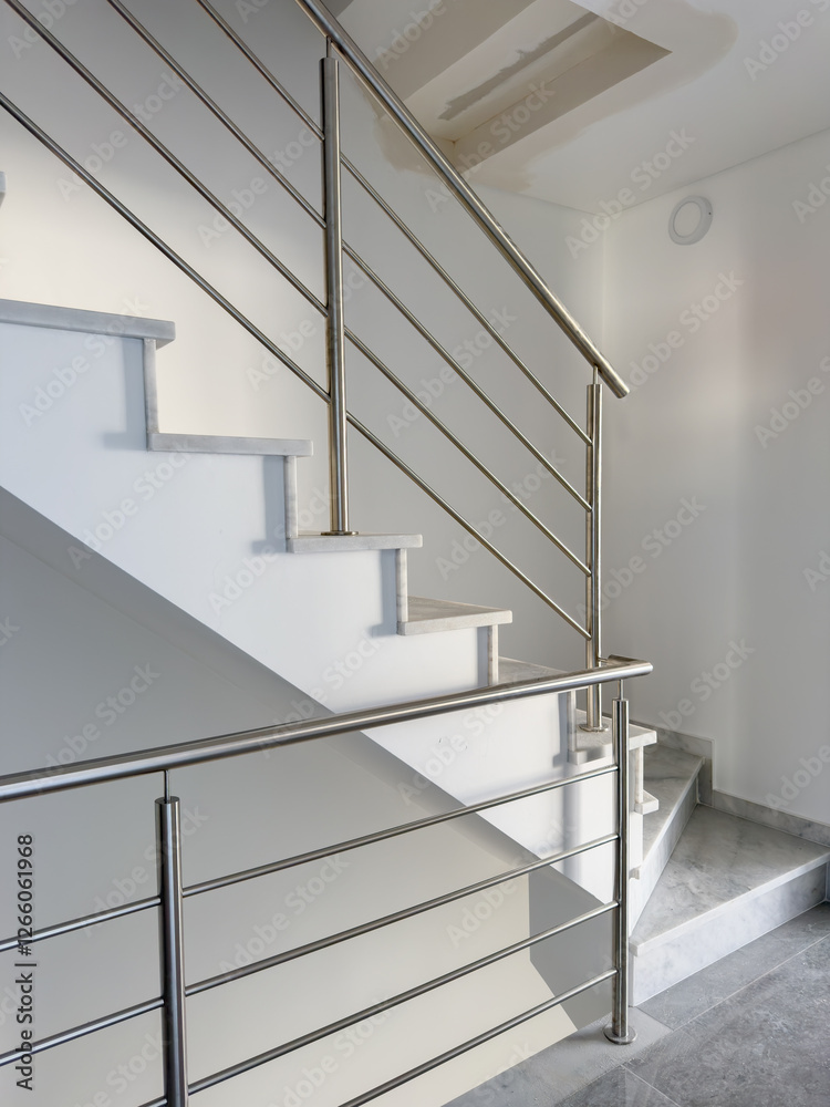 Bright and minimalist stairway leading to an upper floor in a contemporary home. Bright and minimalist stairway leading to an upper floor in a contemporary home.