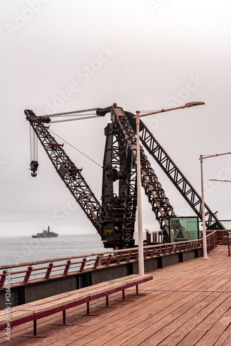Tourists strolling and taking photos at the Vergara Pier in Viña del Mar on a cloudy winter day